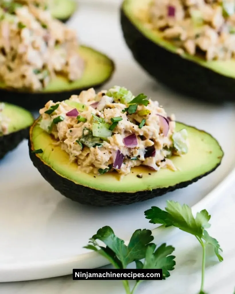Tuna stuffed avocados topped with fresh herbs and vegetables