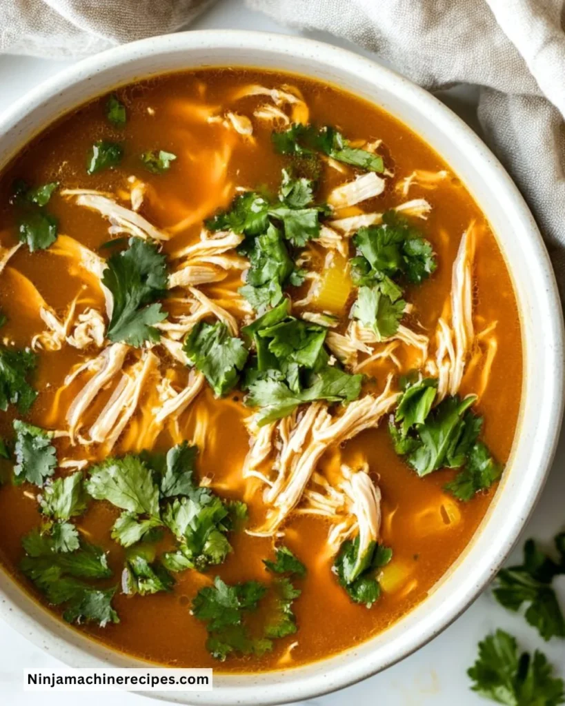 Bowl of Crockpot Chicken Ramen garnished with green onions and soft-boiled egg.