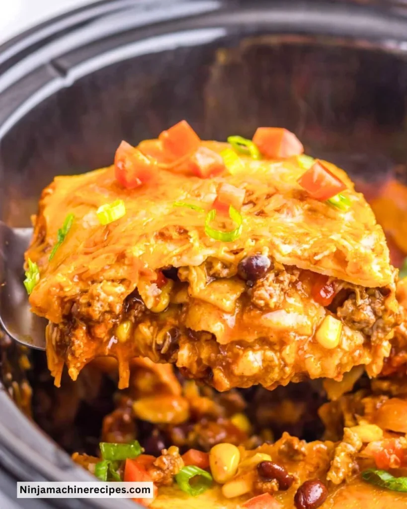 Delicious Crockpot Enchilada Casserole topped with cheese and fresh ingredients