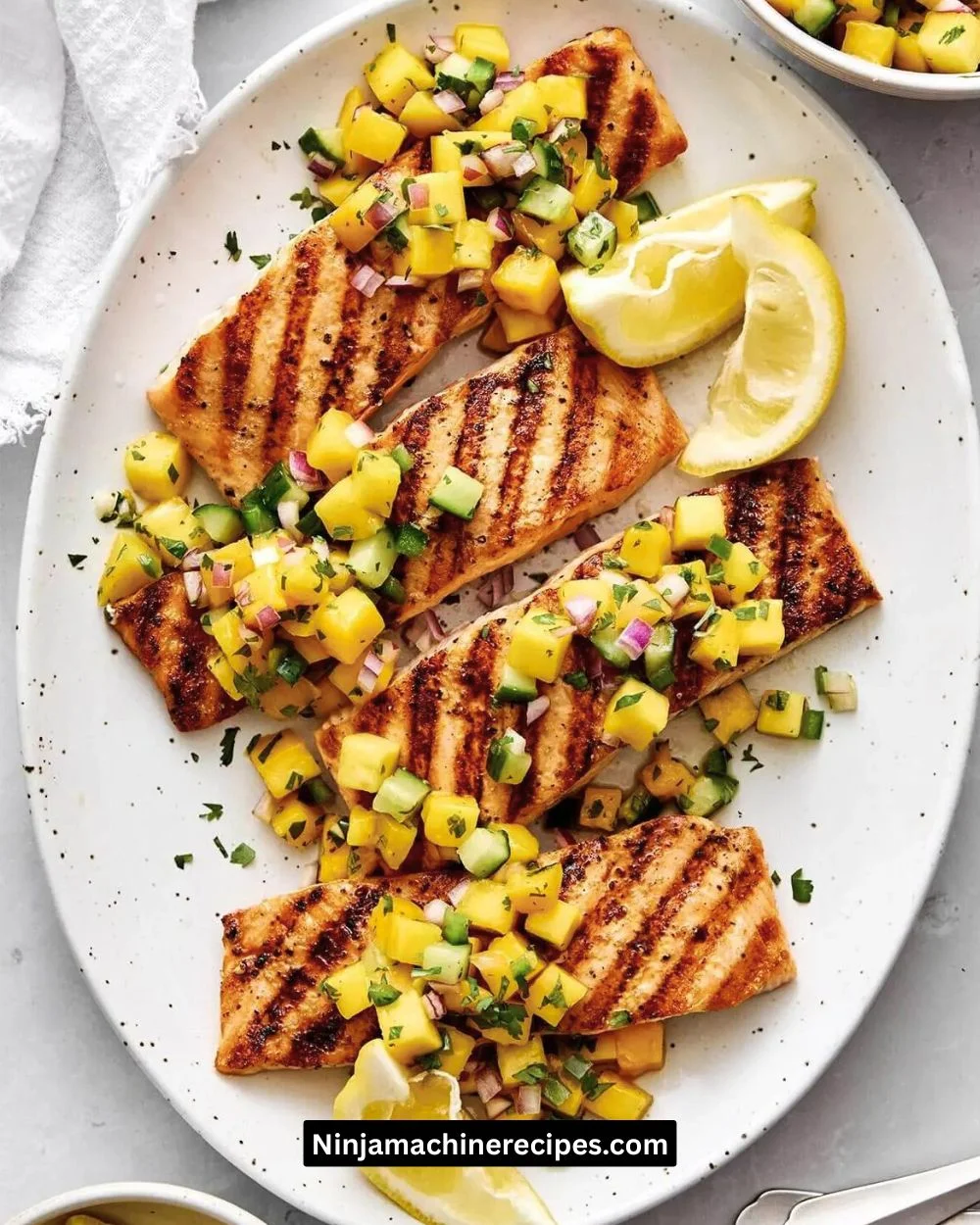Delicious grilled salmon with vibrant mango salsa on a white plate