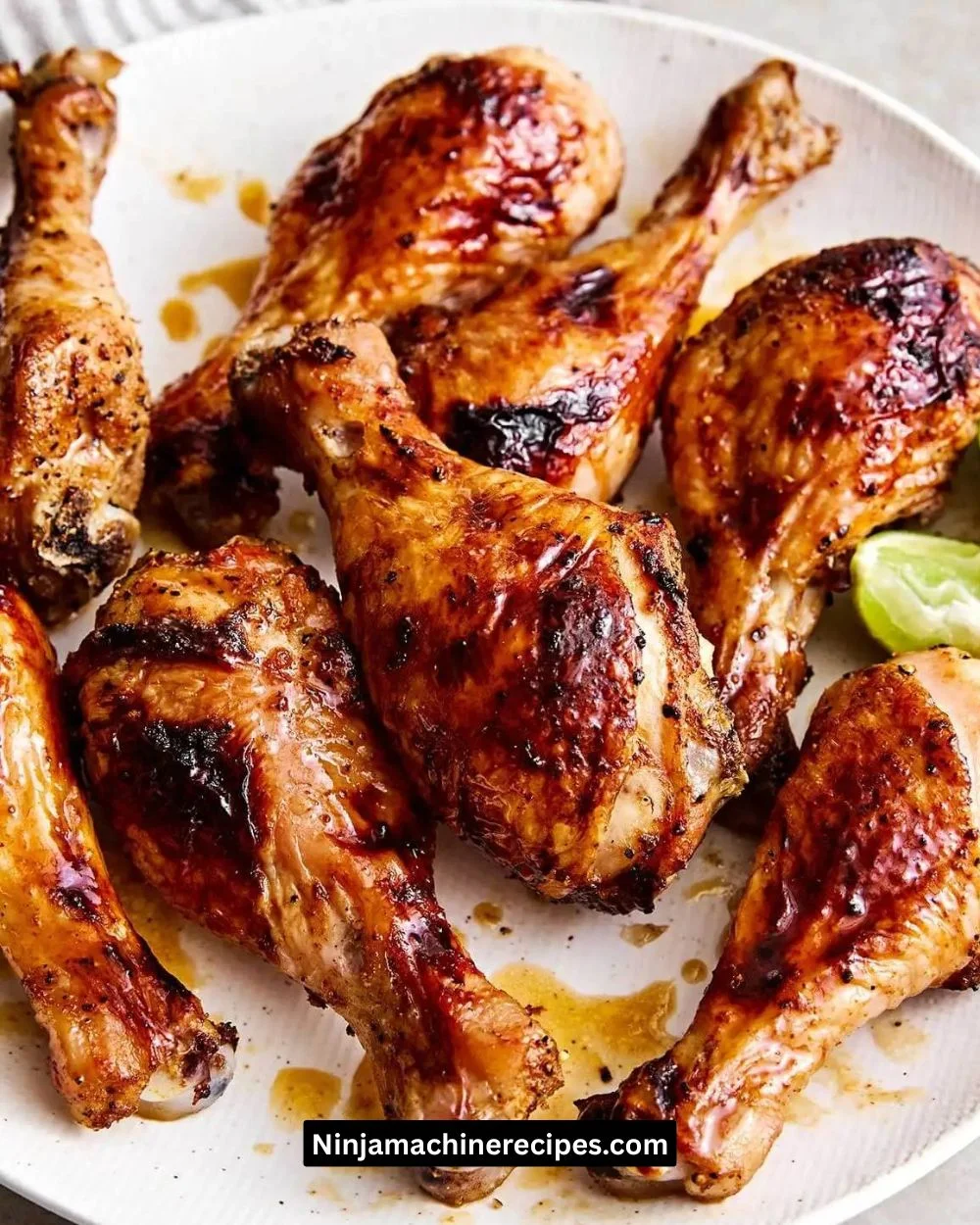 Hot Honey Chicken Drumsticks garnished with herbs on a plate.
