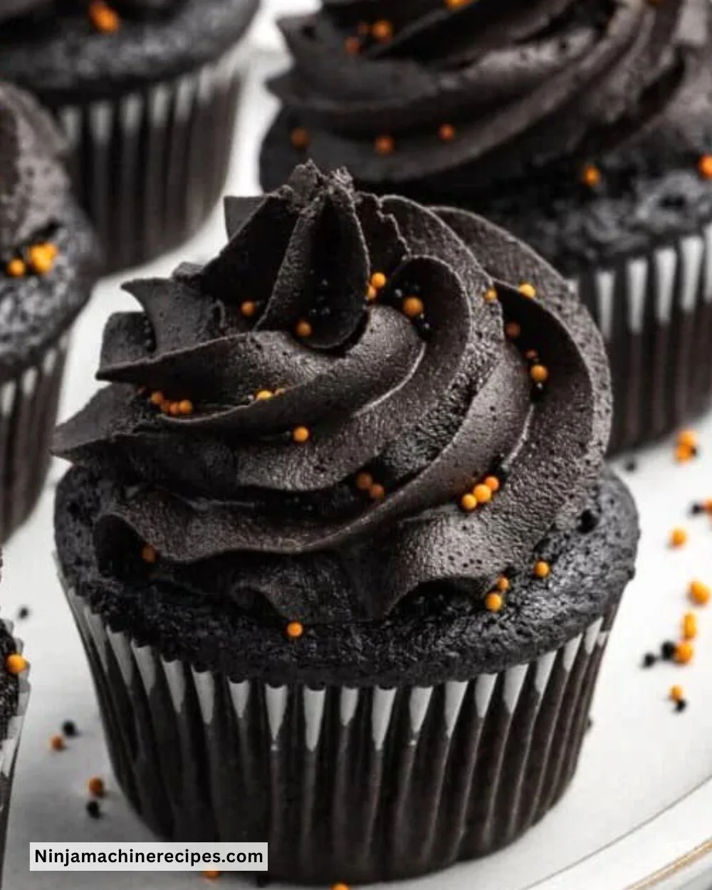 Delicious Black Velvet Cupcakes topped with creamy frosting on a decorative plate.