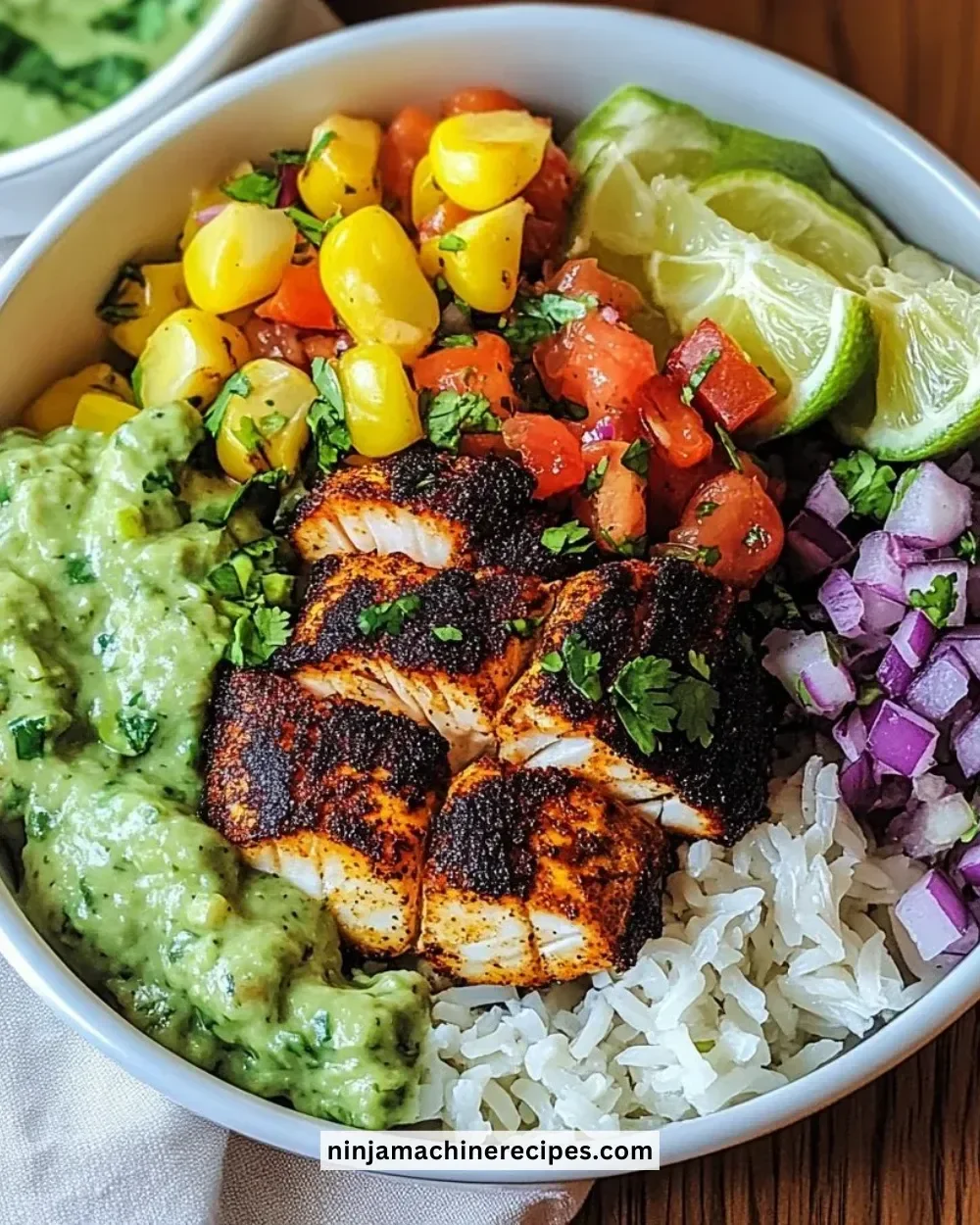 Delicious blackened fish taco bowls topped with fresh ingredients and lime wedges