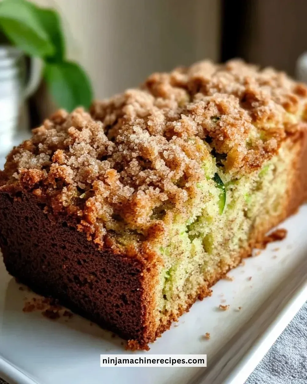 Freshly baked cinnamon streusel topped zucchini bread on a wooden table