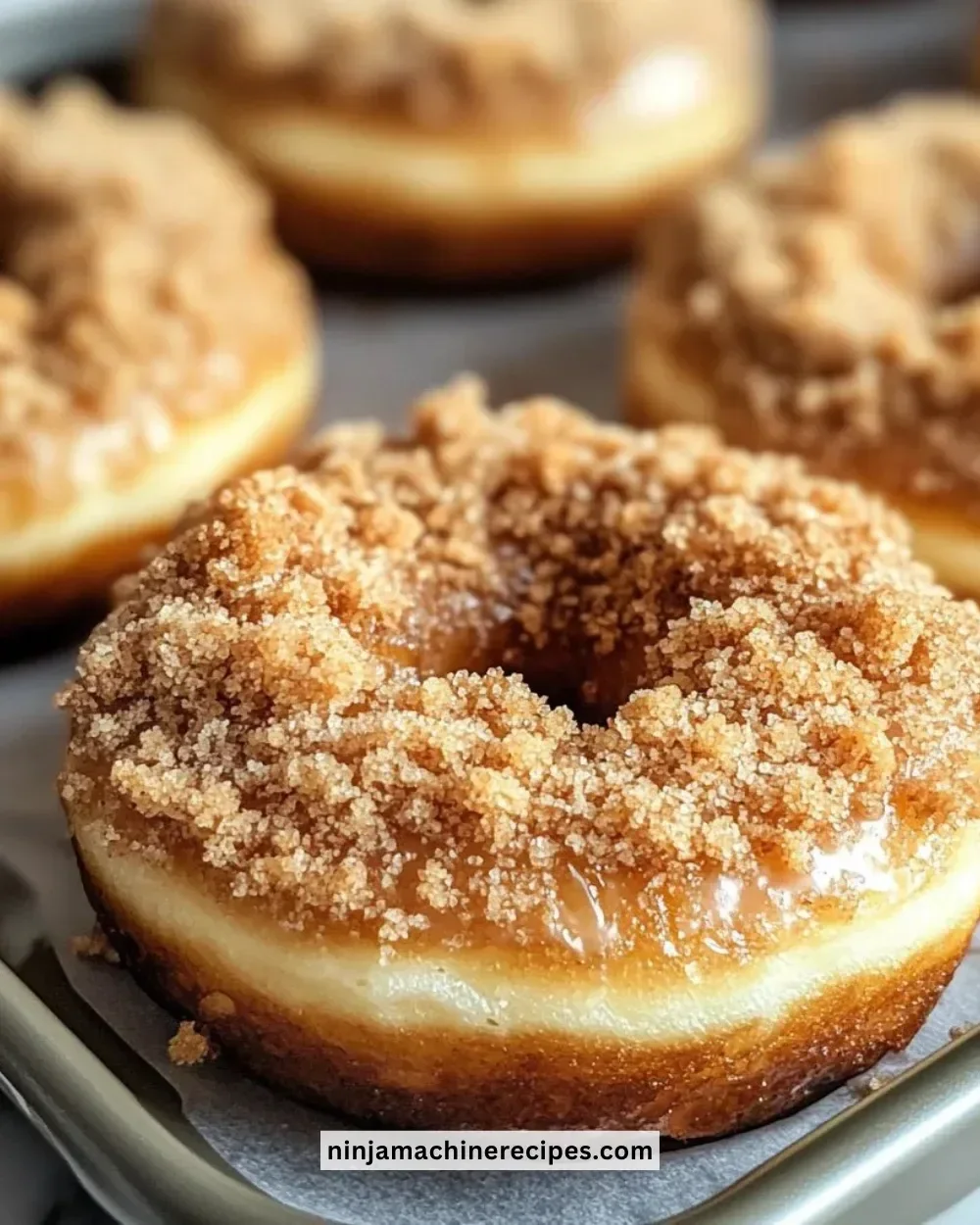 Freshly baked coffee cake donuts with a buttery glaze and sprinkles.