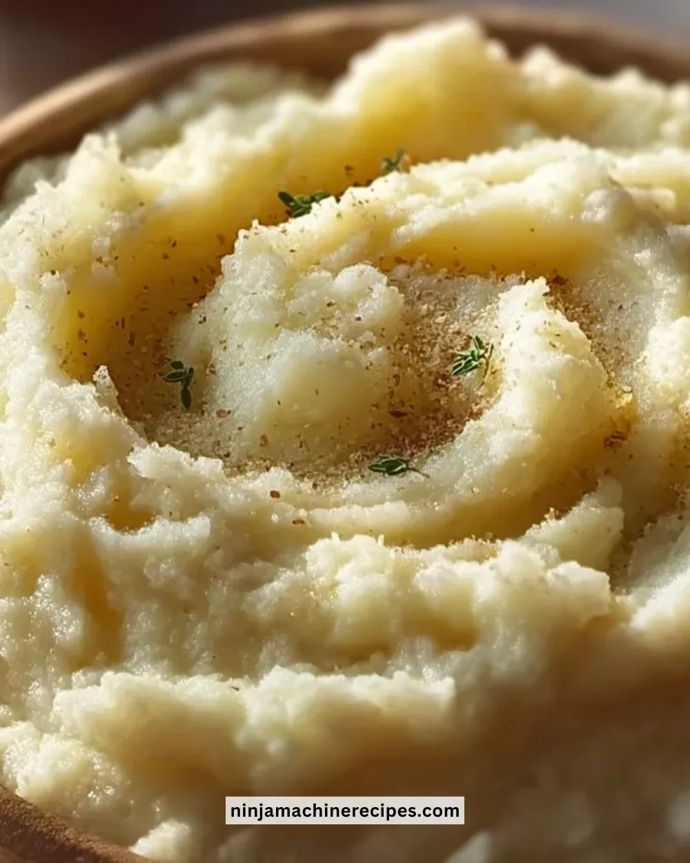 Bowl of creamy cauliflower mash garnished with herbs