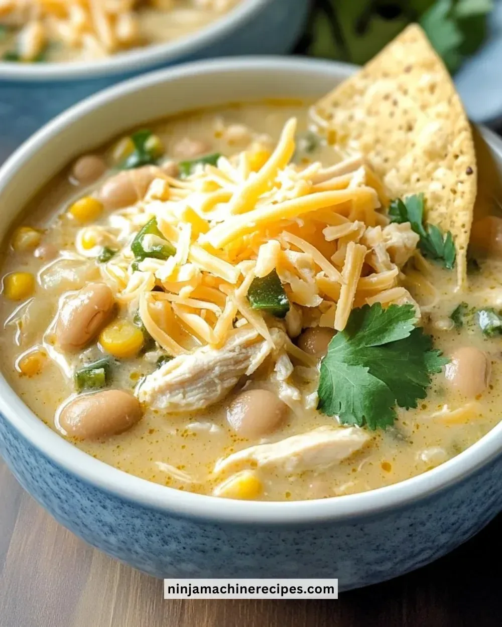 Bowl of creamy white chicken chili topped with cilantro and lime