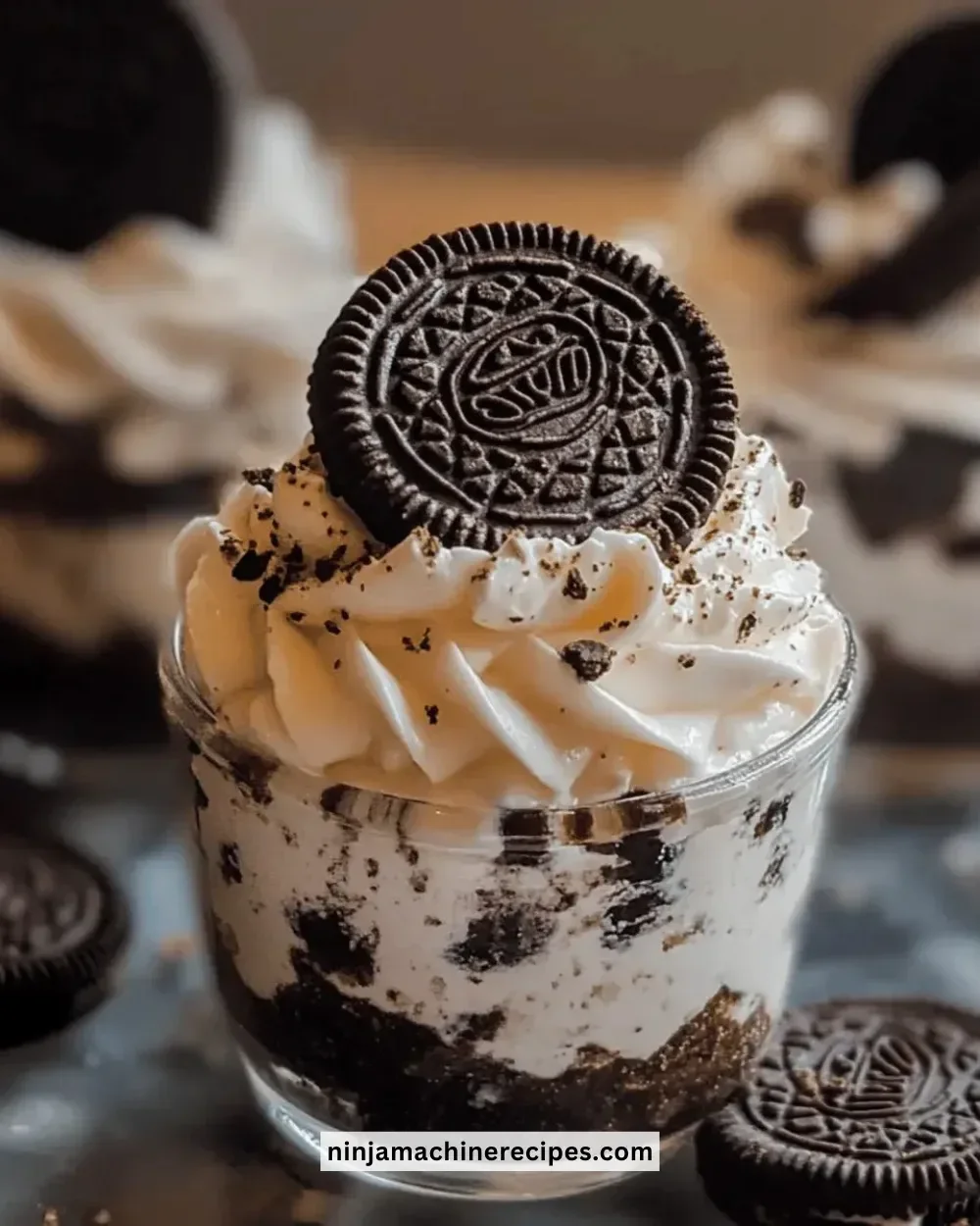 No-bake Oreo cheesecake cups topped with crushed Oreos and whipped cream