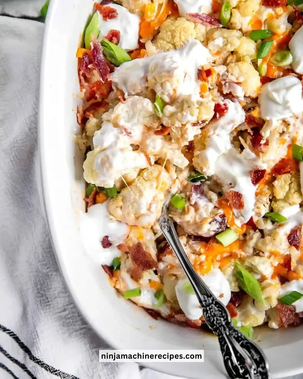 Loaded Cauliflower Casserole topped with cheese and toppings