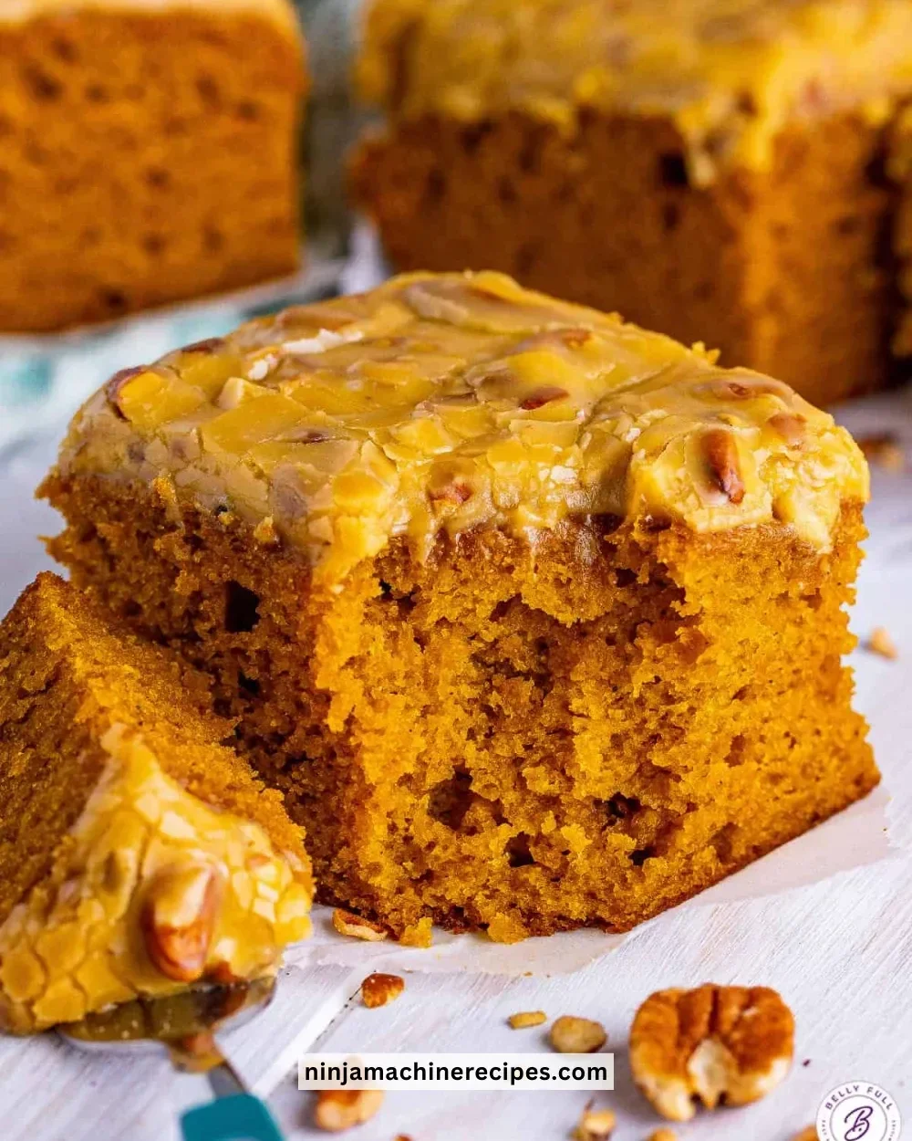 Moist pumpkin cake with praline frosting served on a rustic plate