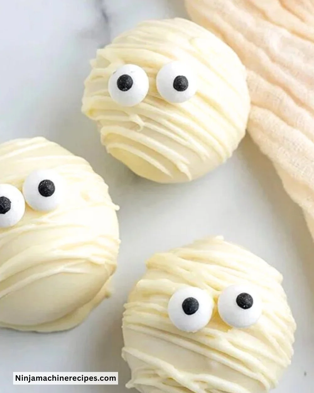 Mummy Oreo Balls decorated for Halloween, featuring white chocolate and candy eyes.