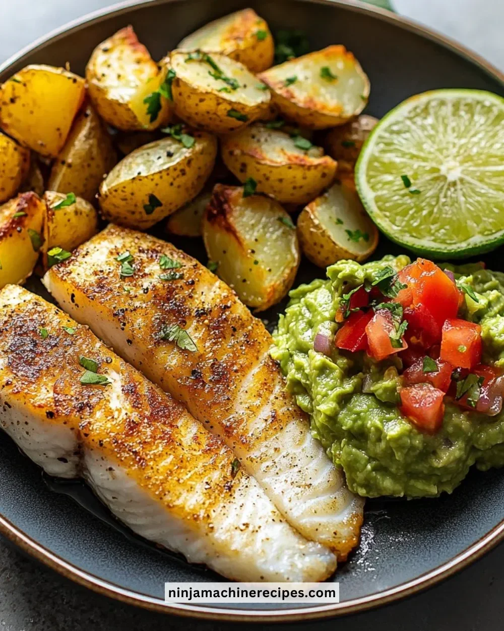 Plate of pan-seared fish with roasted potatoes and guacamole.