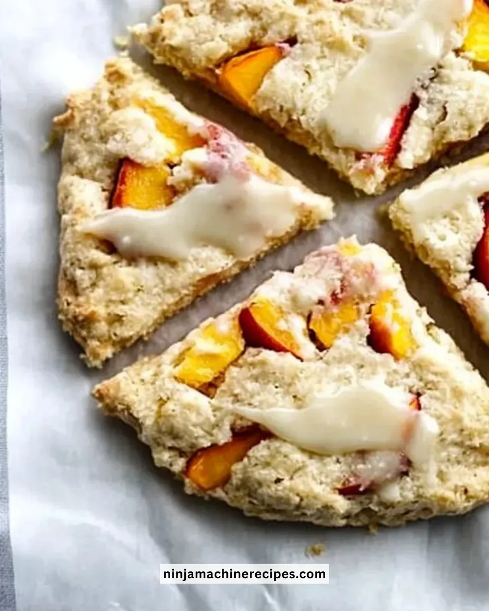 Peach scones topped with honey vanilla glaze on a rustic wooden table
