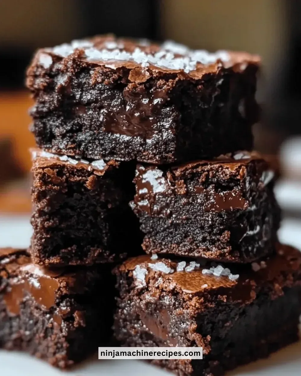 Quick fudgy brownie bites on a white plate with chocolate drizzle