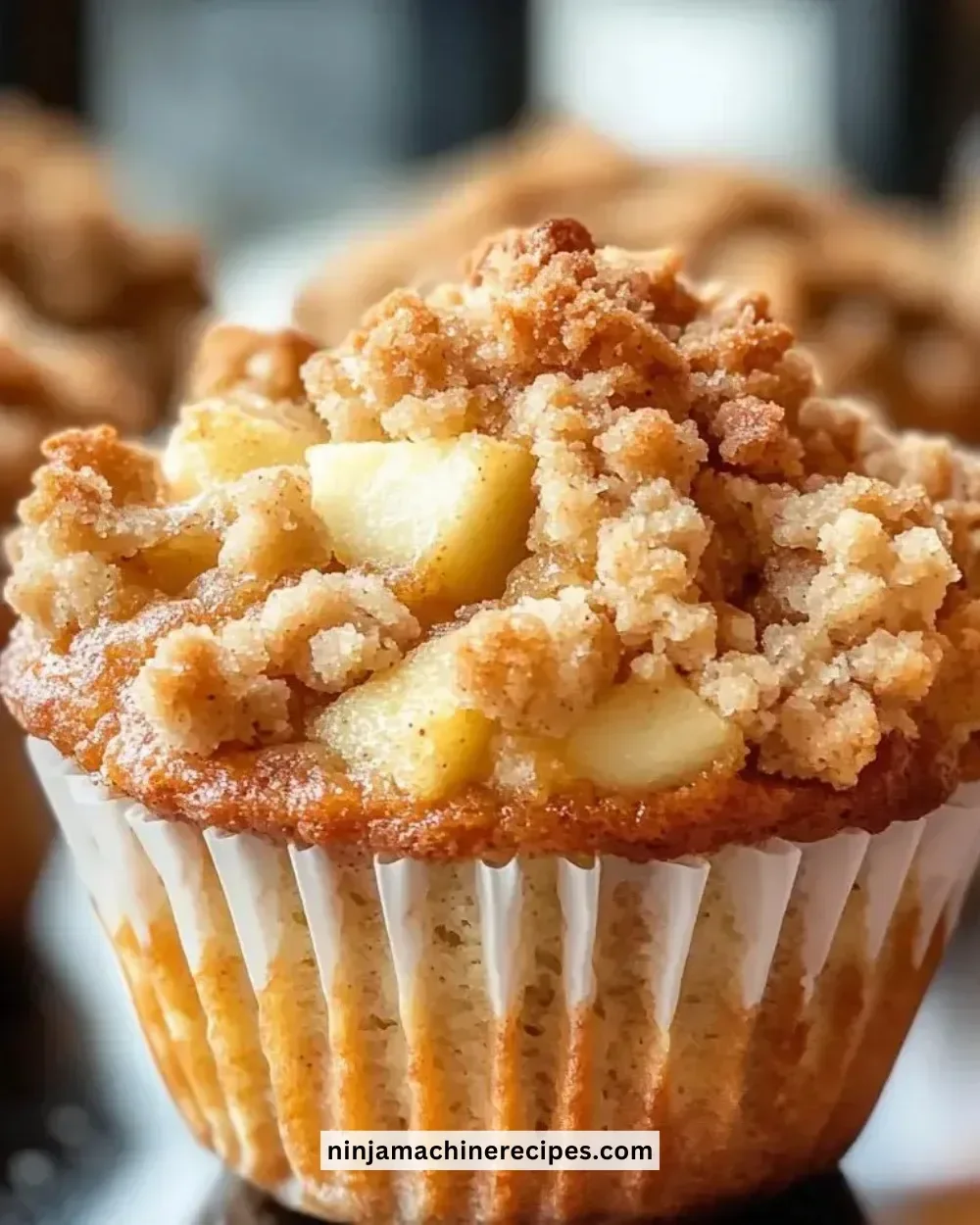 Freshly baked apple crumble muffins with a crunchy topping and juicy apple filling.