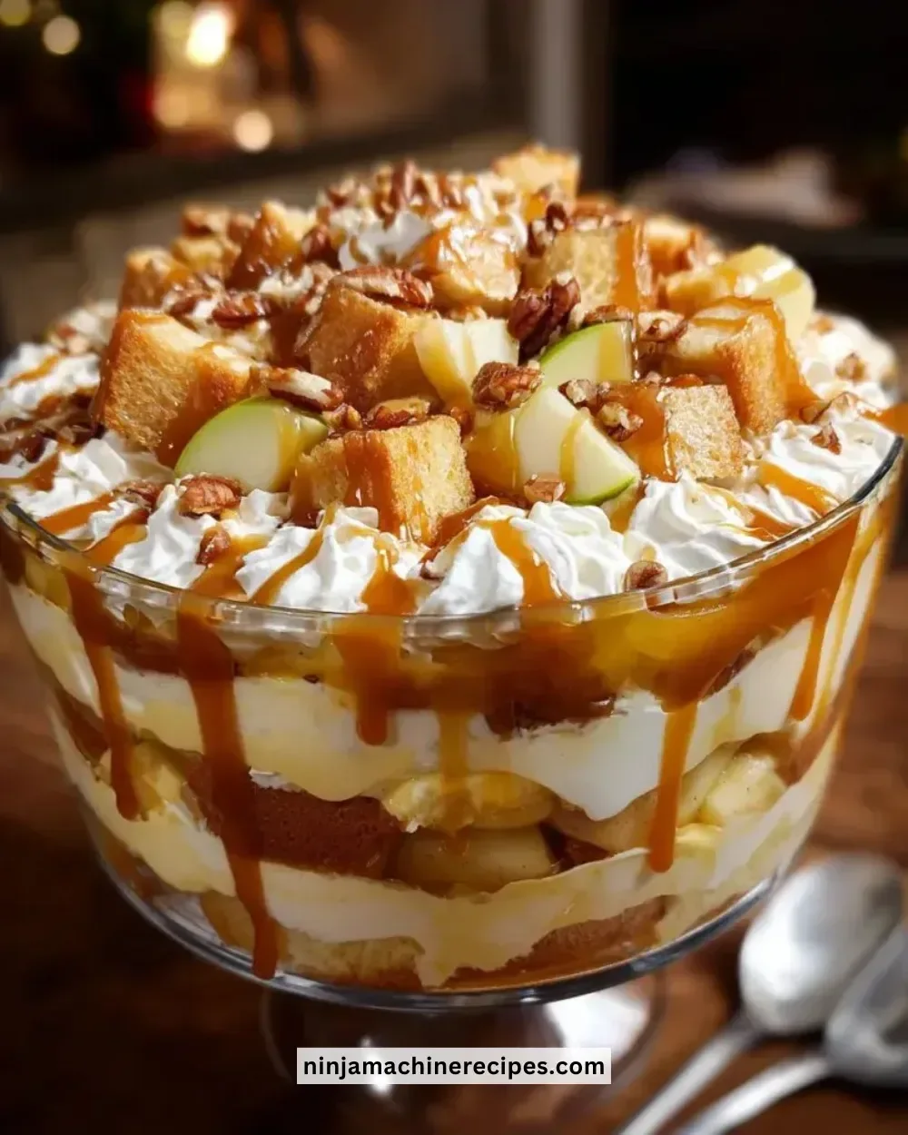 Caramel apple trifle layered with apples, caramel, and cream in a glass dish.