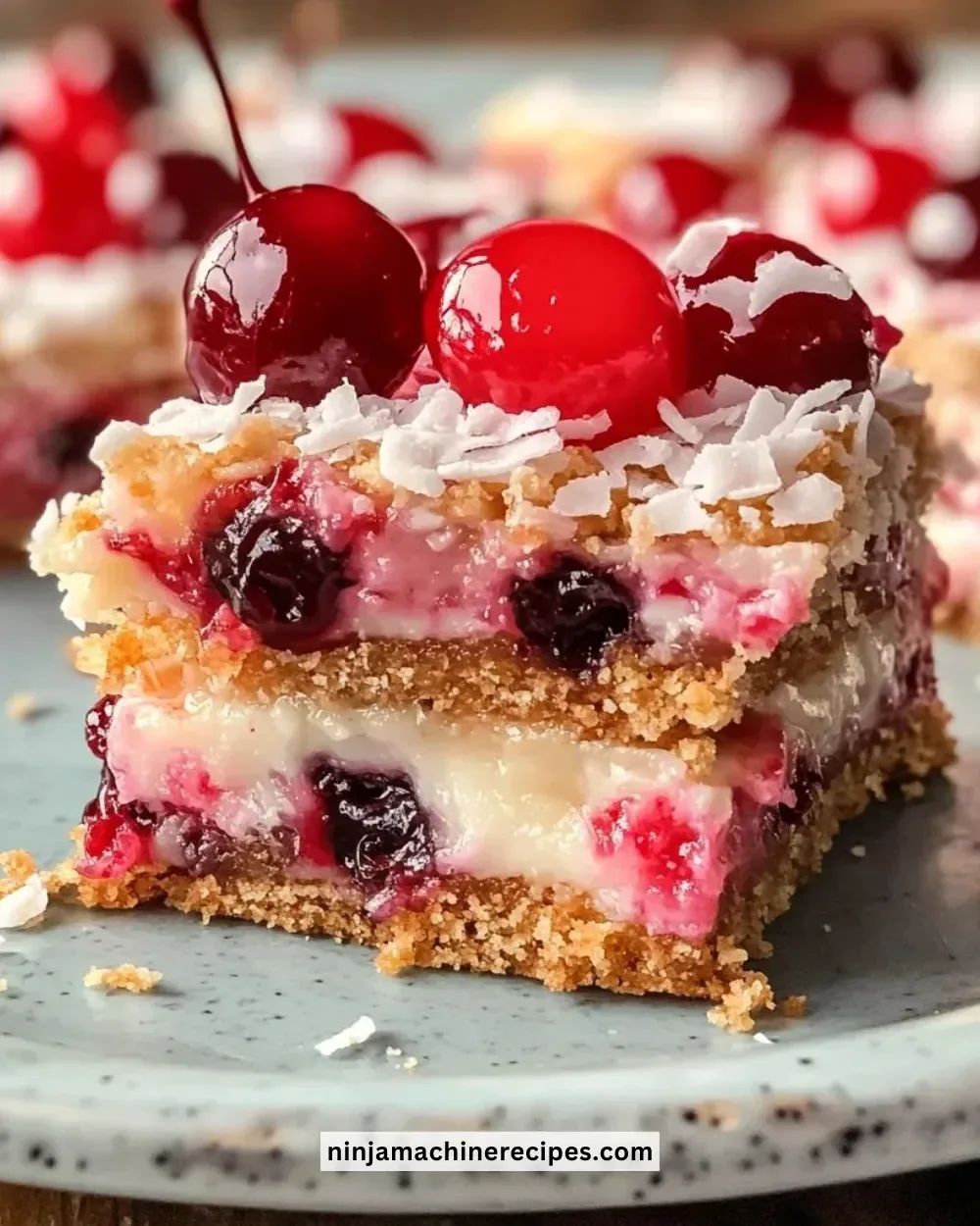 Chewy cherry coconut magic bars stacked on a wooden table, ready to enjoy