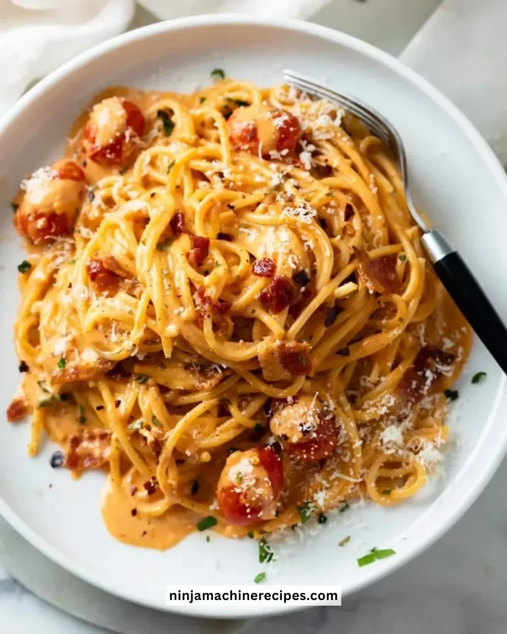 Creamy bacon pasta dish garnished with herbs and served in a bowl