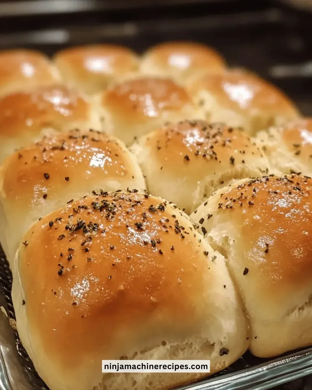 Freshly baked easy buttery herb dinner rolls on a wooden table.