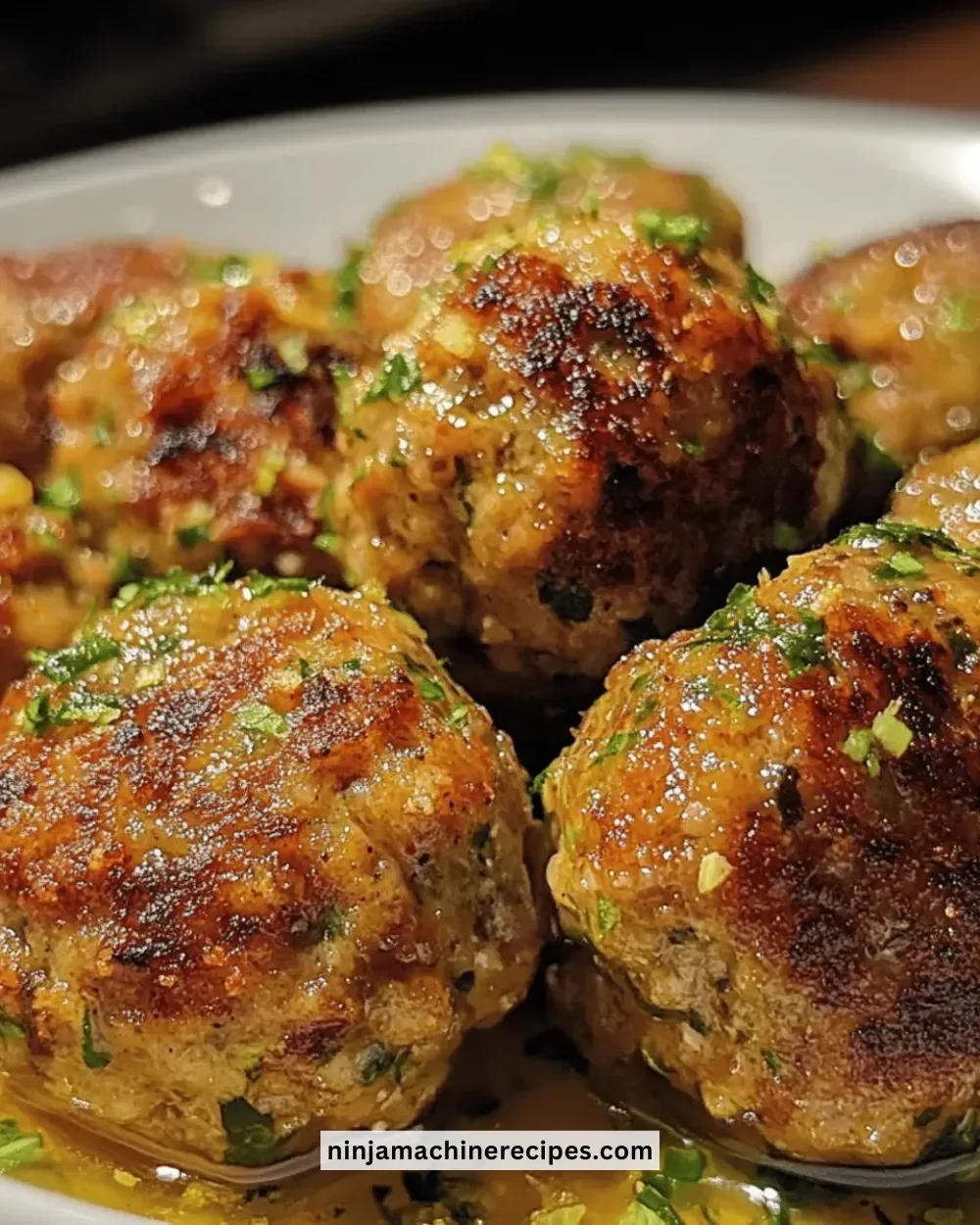 Savory roasted turkey meatballs served on a plate with herbs and sauce