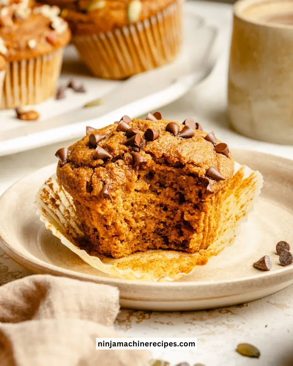 Healthy pumpkin muffins on a wooden table with spices and pumpkin puree.