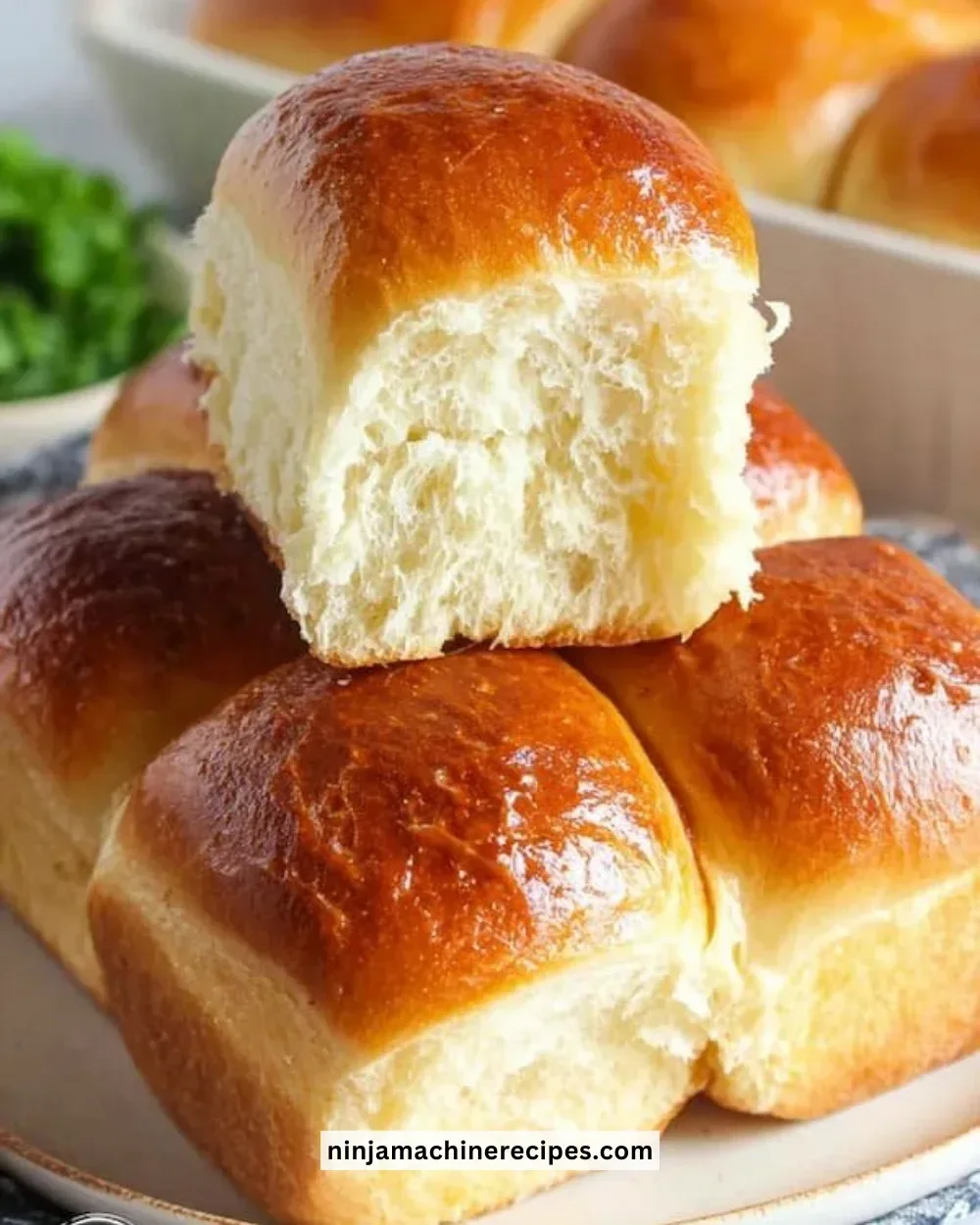 Freshly baked homemade dinner rolls on a wooden table.