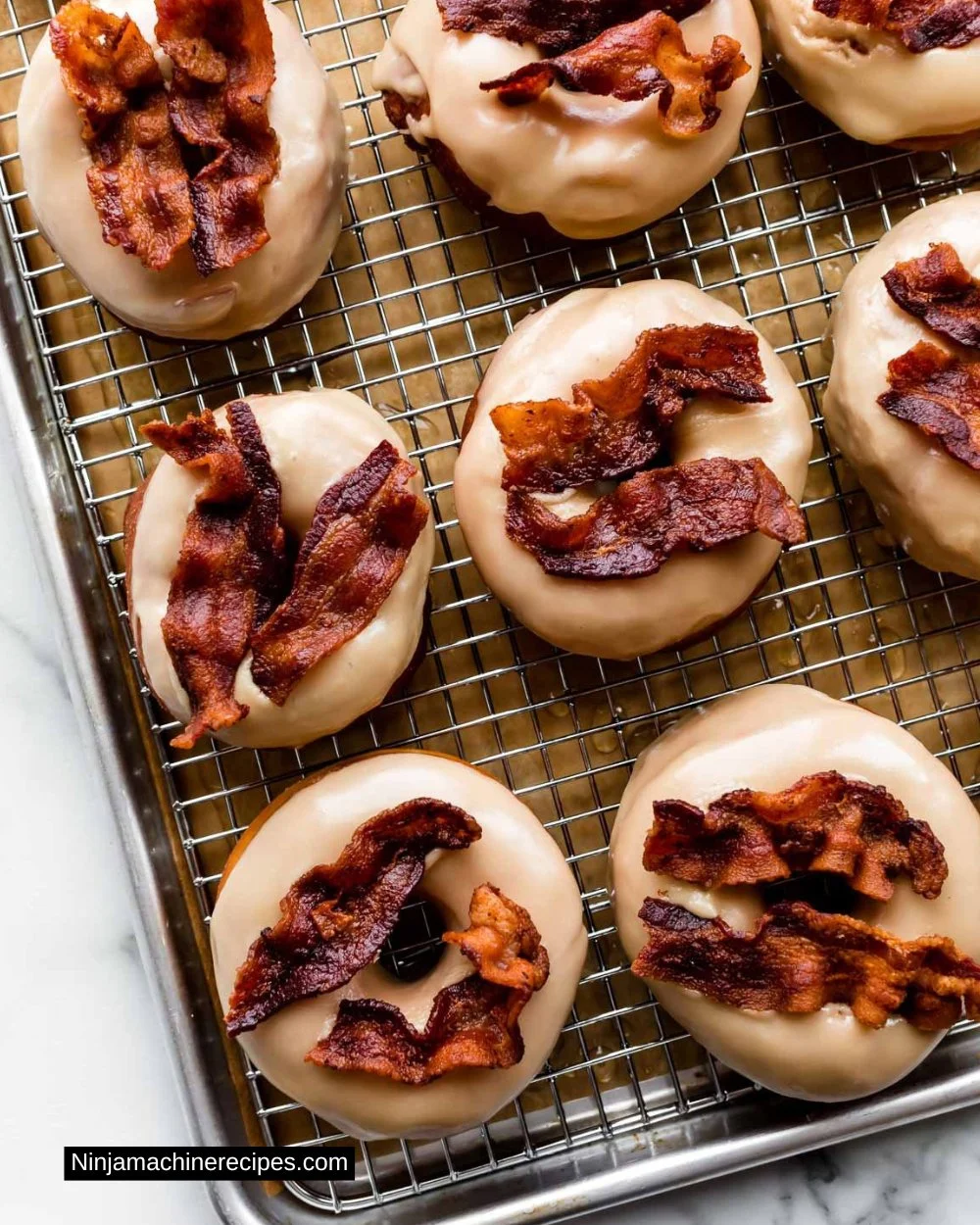 Delicious homemade maple bacon doughnuts topped with crispy bacon and maple glaze.
