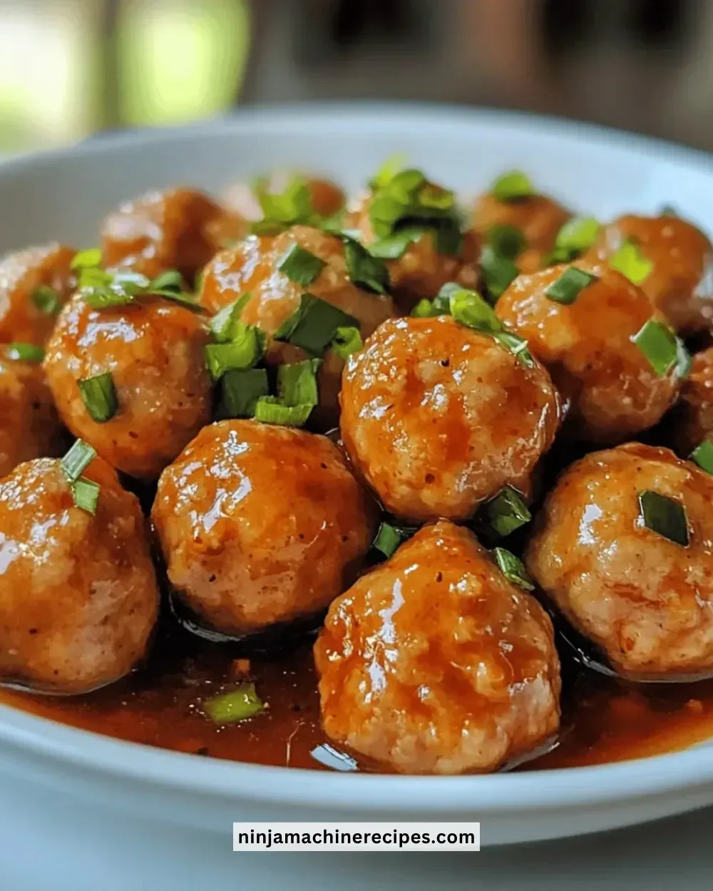Juicy sweet chili chicken meatballs topped with sauce and garnished with herbs