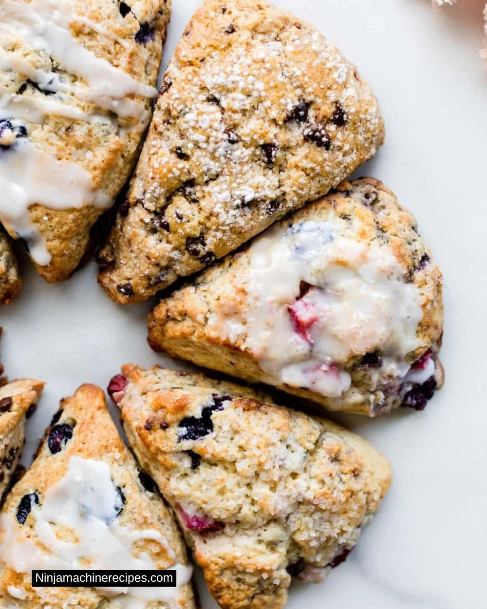 Freshly baked scones arranged on a plate with clotted cream and jam