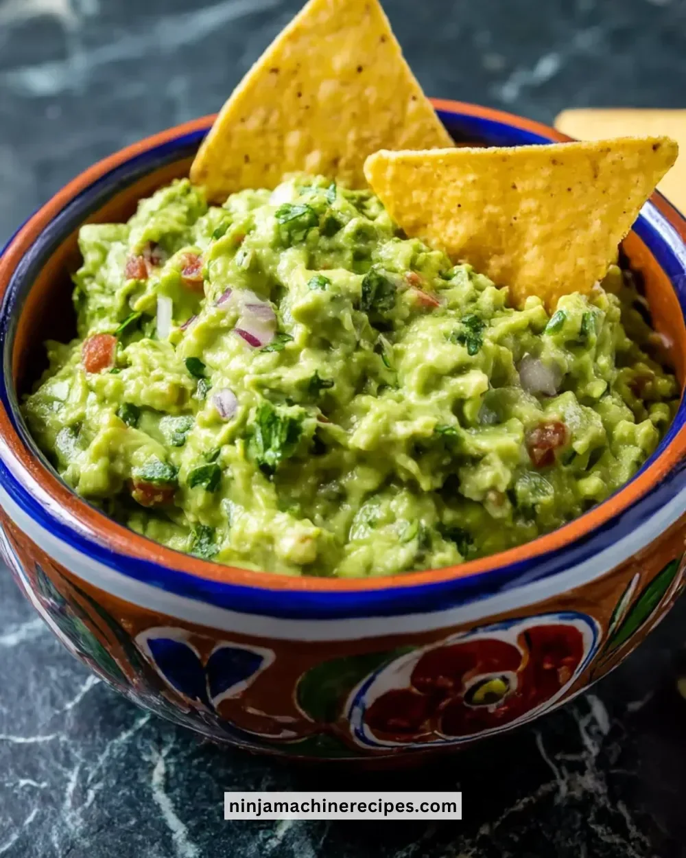 A bowl of perfectly made guacamole with fresh ingredients