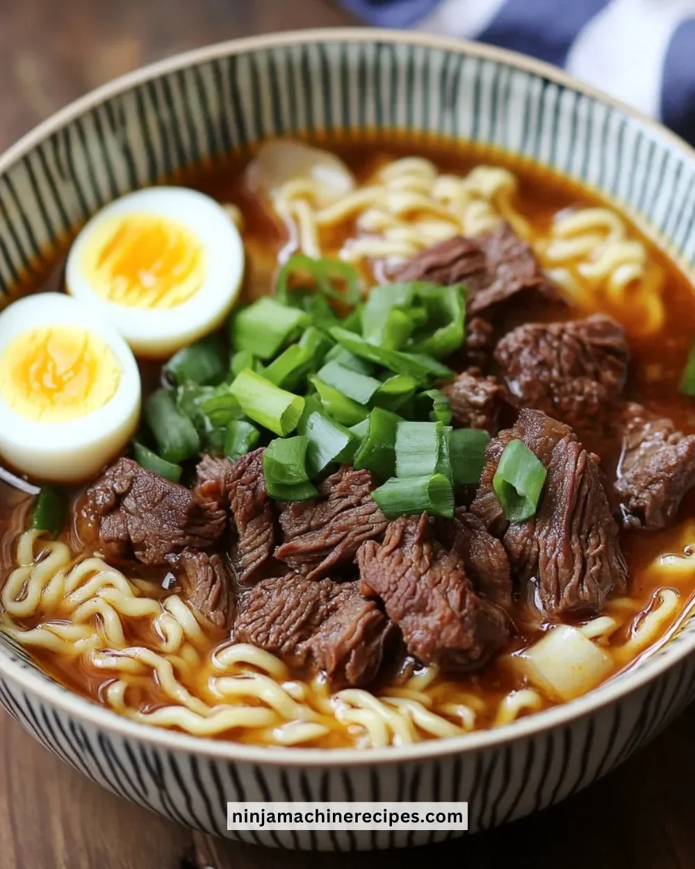 Slow cooker beef ramen noodles topped with fresh herbs and vegetables