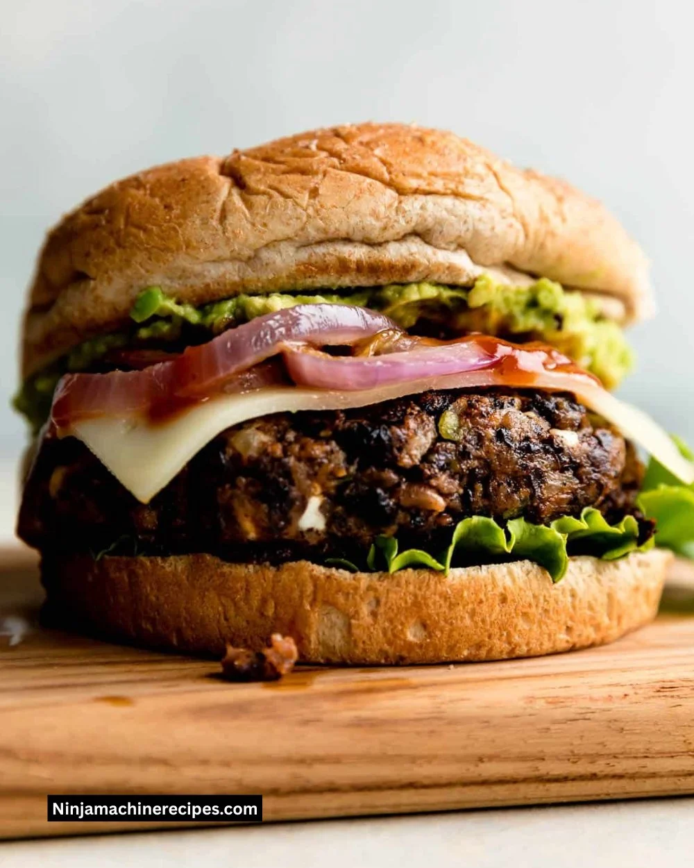Plate of homemade black bean burgers with fresh toppings and herbs.