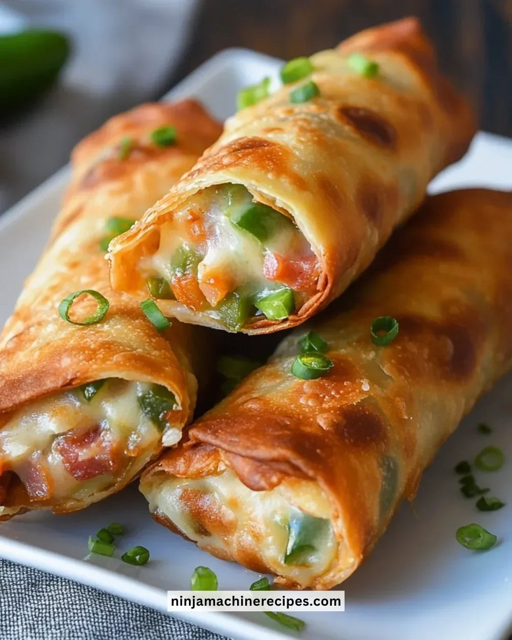 Turkey bacon jalapeño popper eggrolls served on a plate with dipping sauce