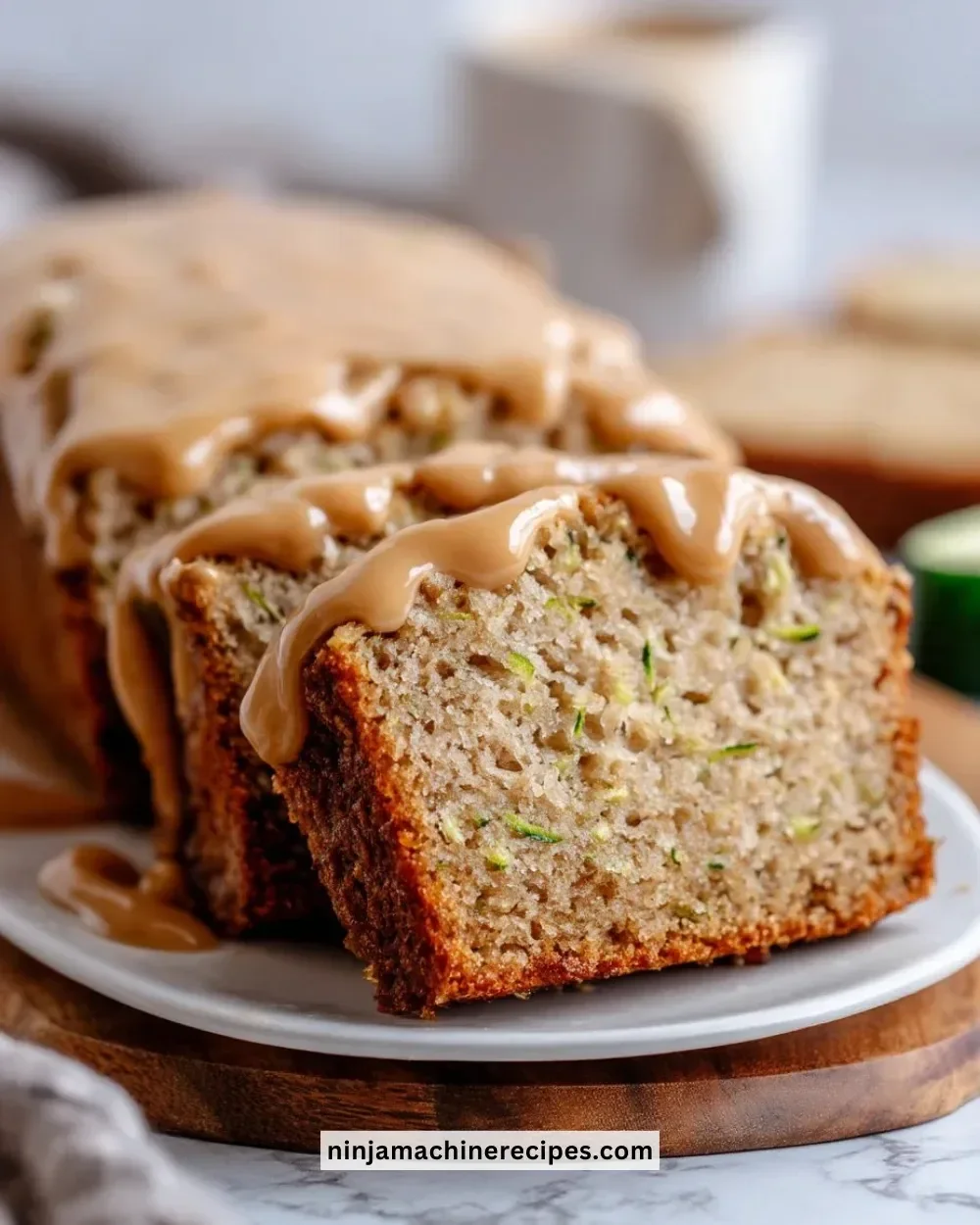 Apple zucchini bread with brown sugar frosting on a rustic wooden table