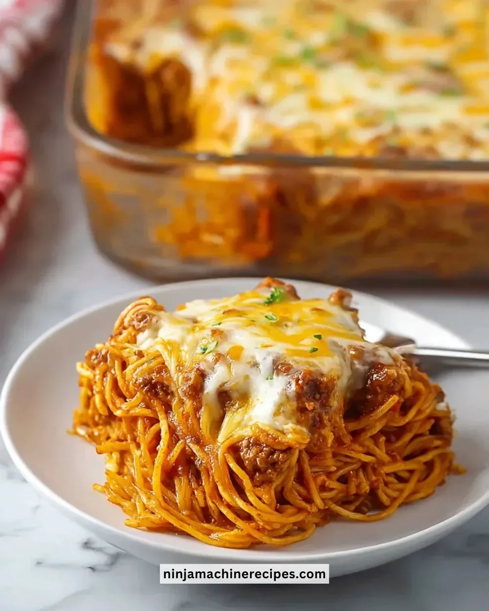 Baked Cream Cheese Spaghetti Casserole with melted cheese and herbs