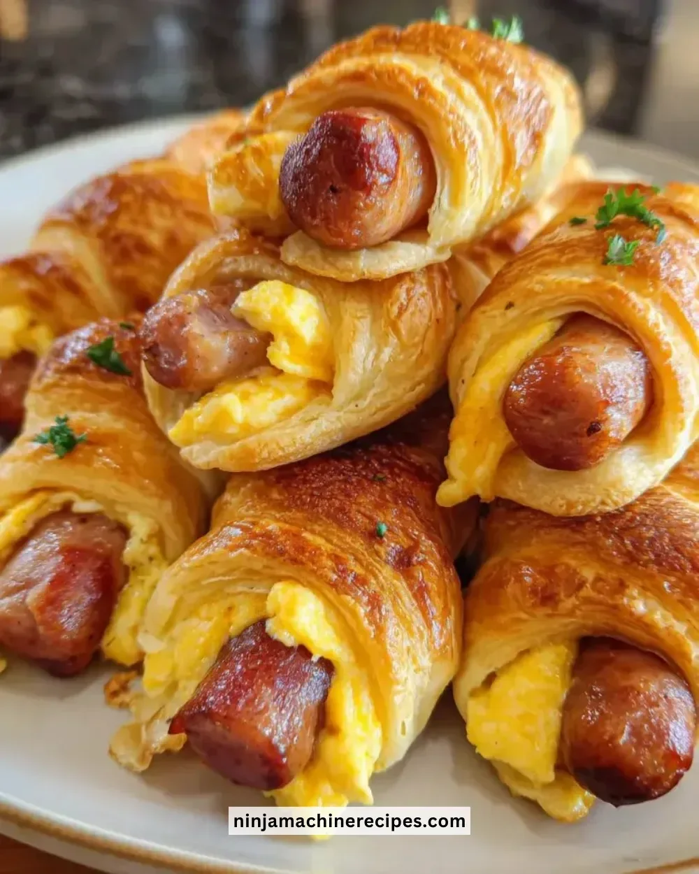 Breakfast Pigs in Blanket served on a plate with dipping sauce