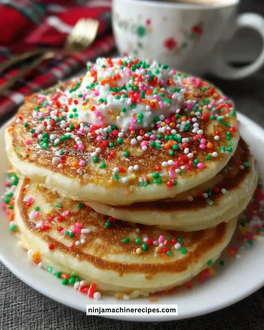 Fluffy Christmas pancakes topped with berries and whipped cream.