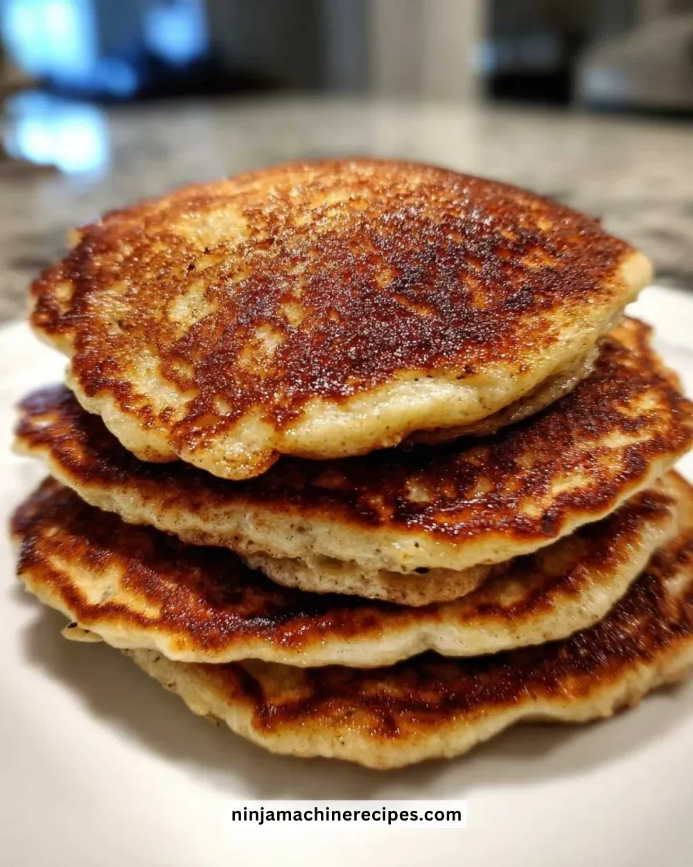 Fluffy banana bread pancakes stacked on a plate with syrup and bananas