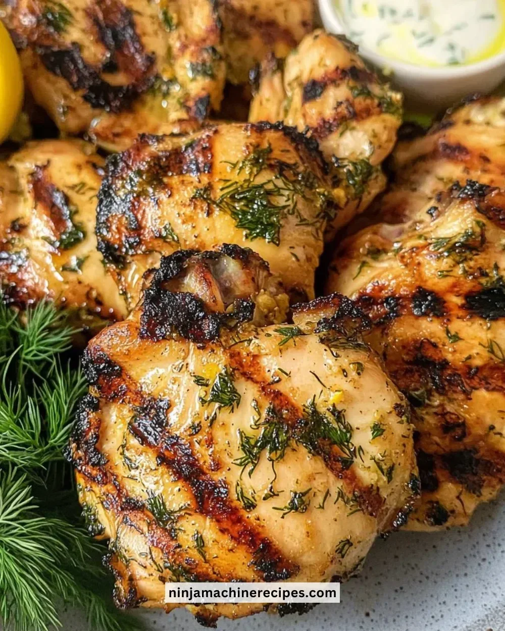 Greek Yogurt Marinated Chicken on a serving plate with herbs and spices.