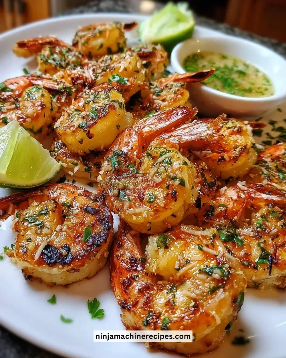 Grilled coconut lime shrimp served on a plate with fresh lime wedges and herbs.
