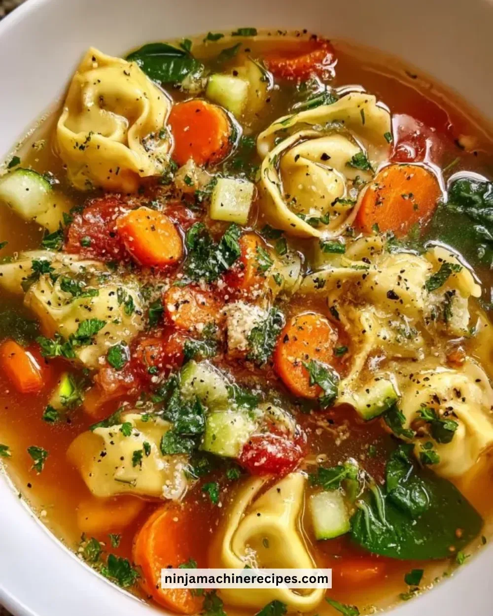 Bowl of healthy tortellini soup with vegetables and herbs