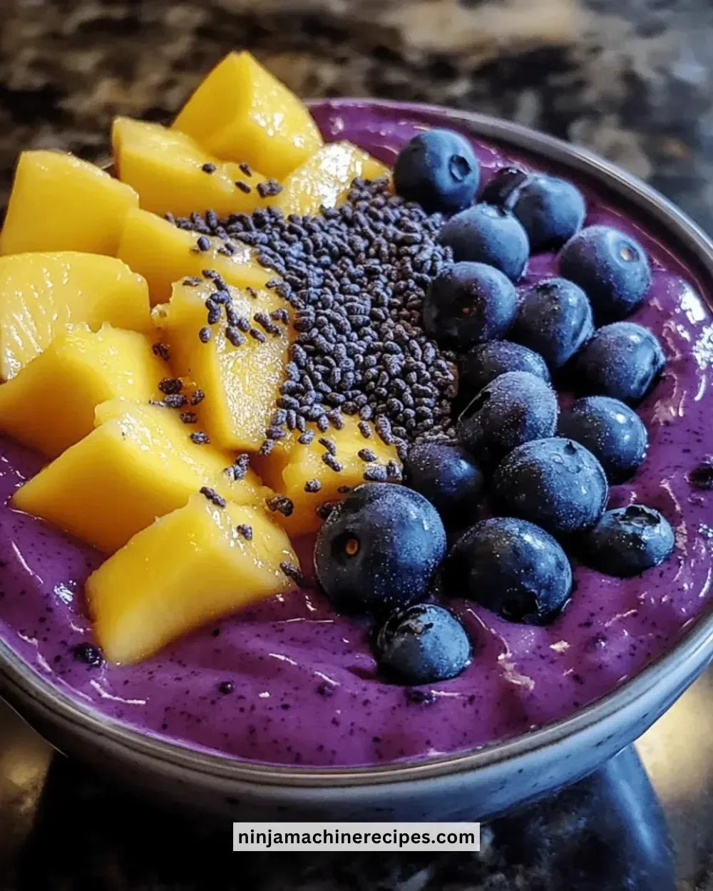 Delicious Mango Blueberry Smoothie Bowl topped with fresh fruit and nuts