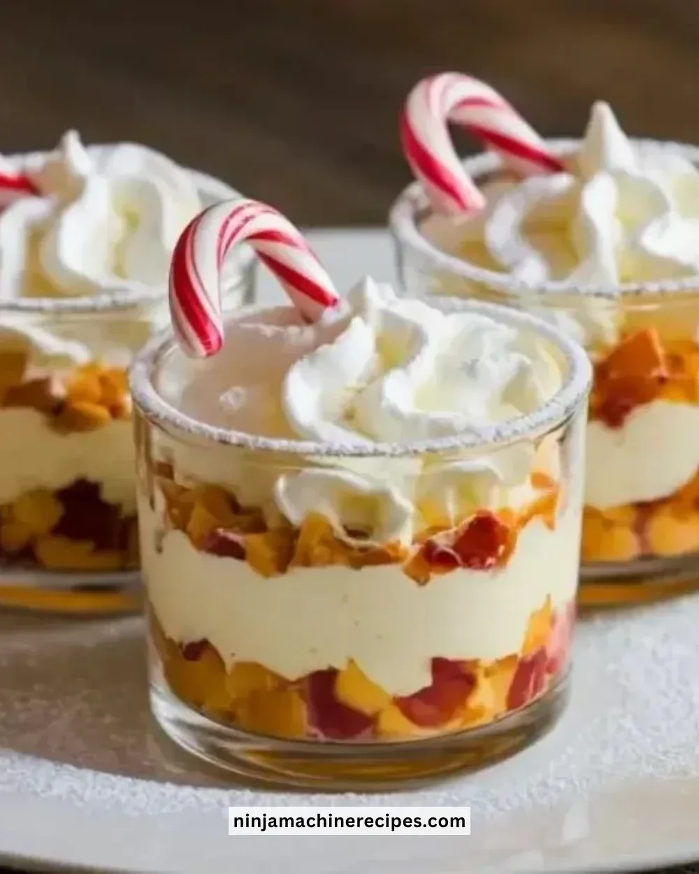 Mini Christmas Trifles served in festive cups with layers of cream and fruit