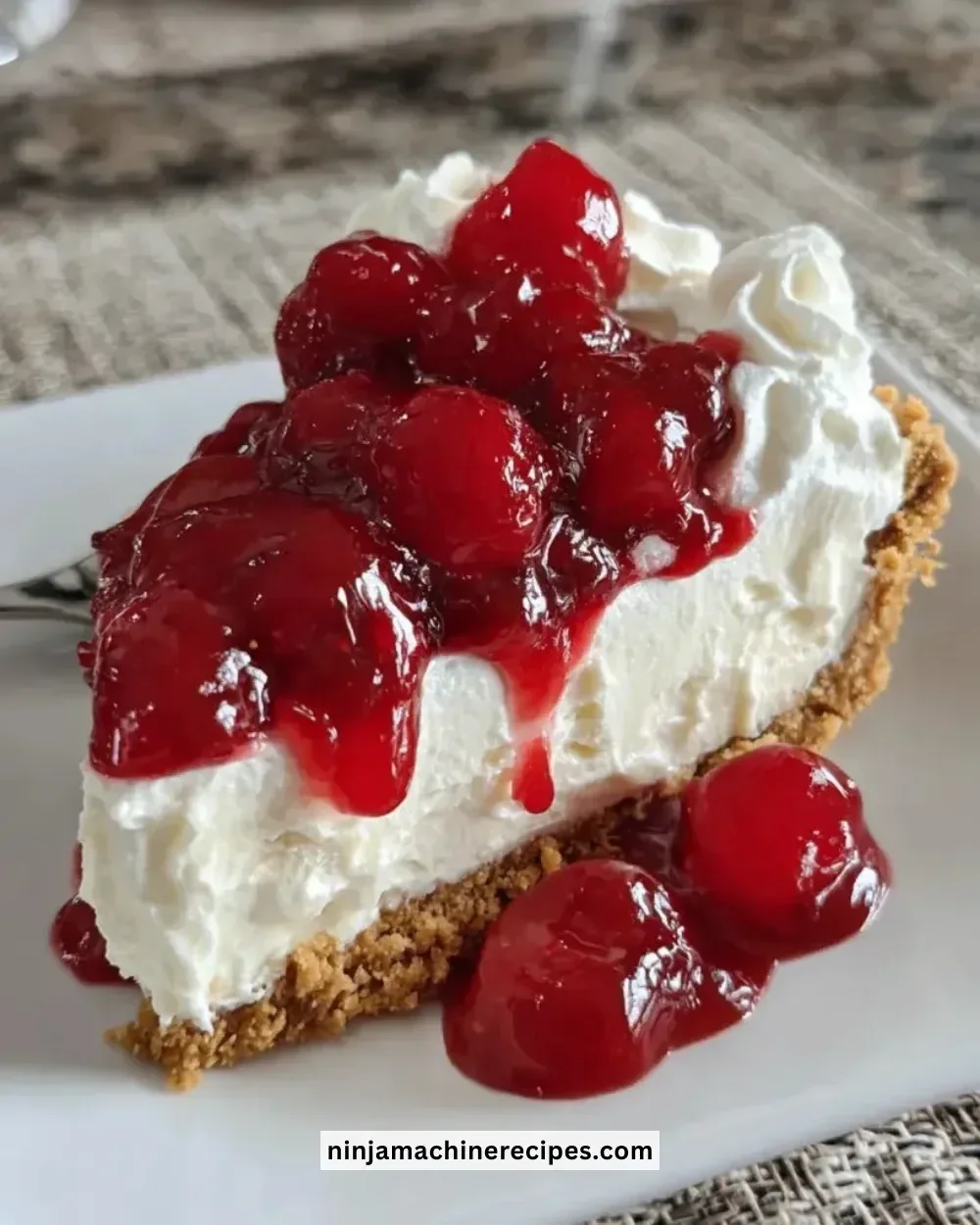 No-bake cherry cheesecake topped with fresh cherries and whipped cream.