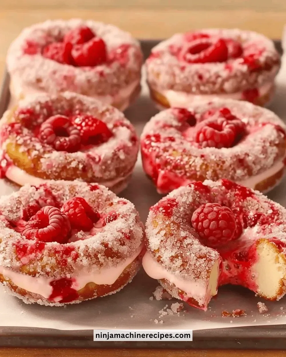 Delicious Raspberry Cheesecake Donuts filled with creamy filling and topped with raspberry.