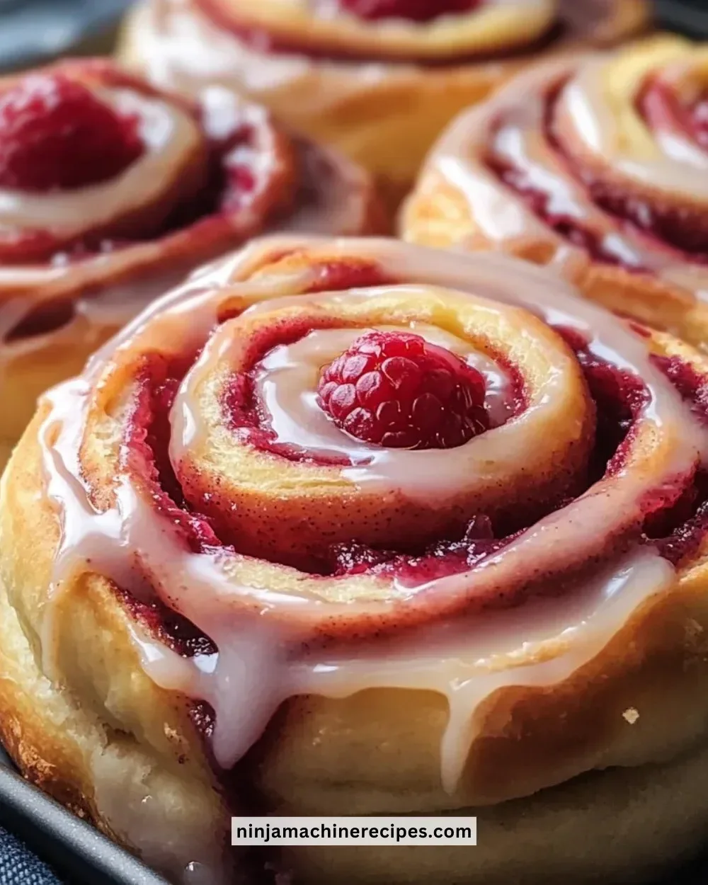 Freshly baked raspberry cinnamon rolls with a creamy glaze.