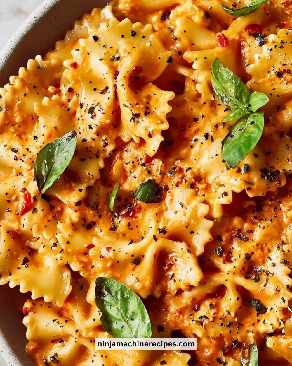 Bowl of speedy sun-dried tomato pasta garnished with fresh basil