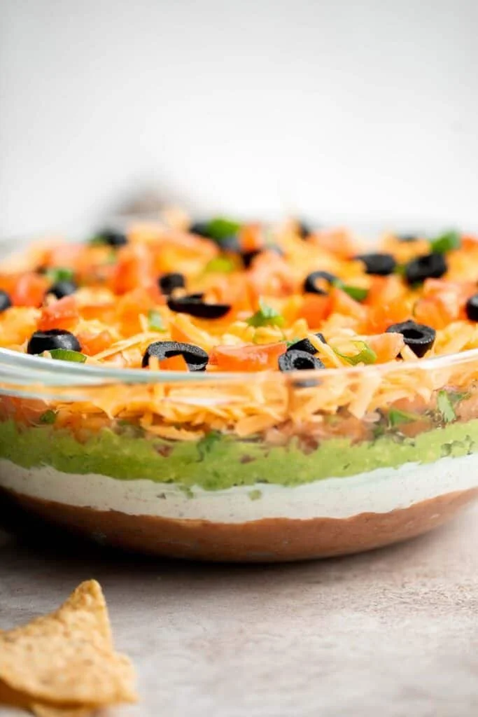 Delicious 7 Layer Dip with colorful layers of beans, cheese, and salsa