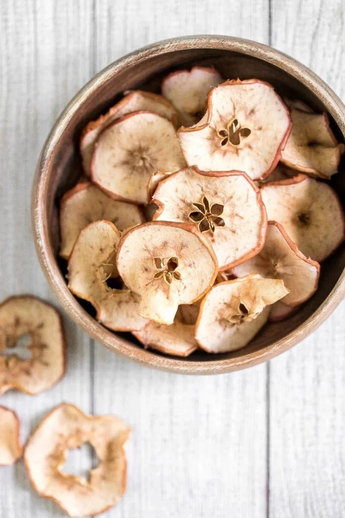 Homemade baked apple chips served in a bowl for healthy snacking