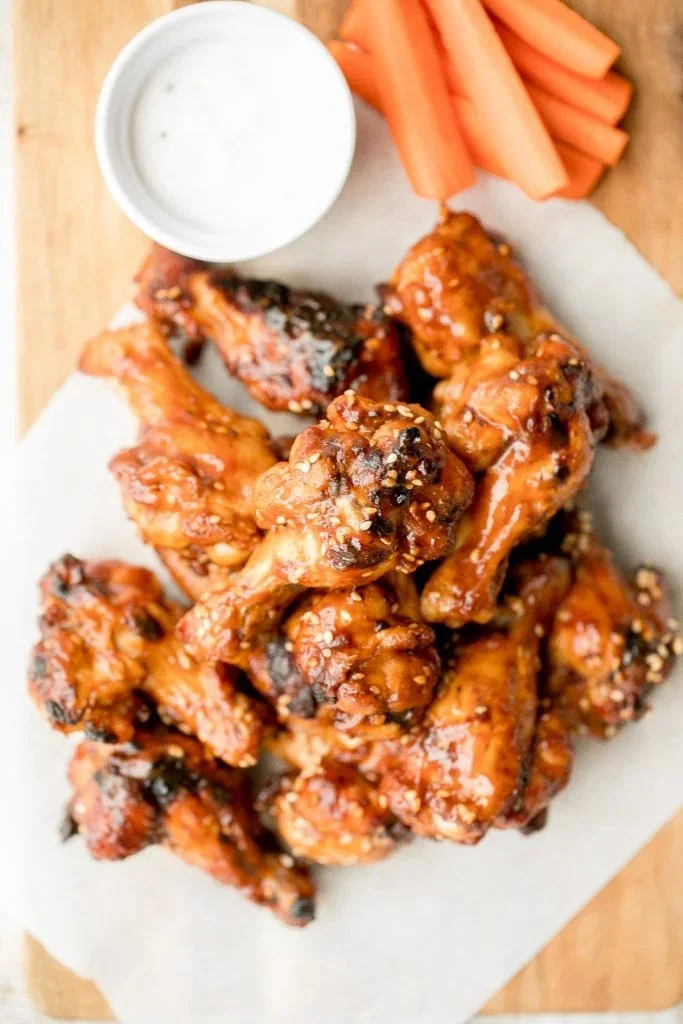 Baked BBQ chicken wings served on a platter with dipping sauce